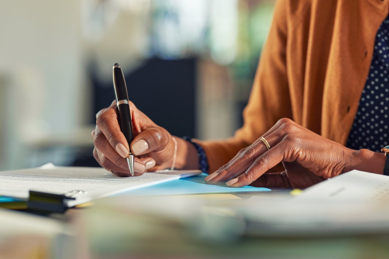 business woman signing papers at her desk